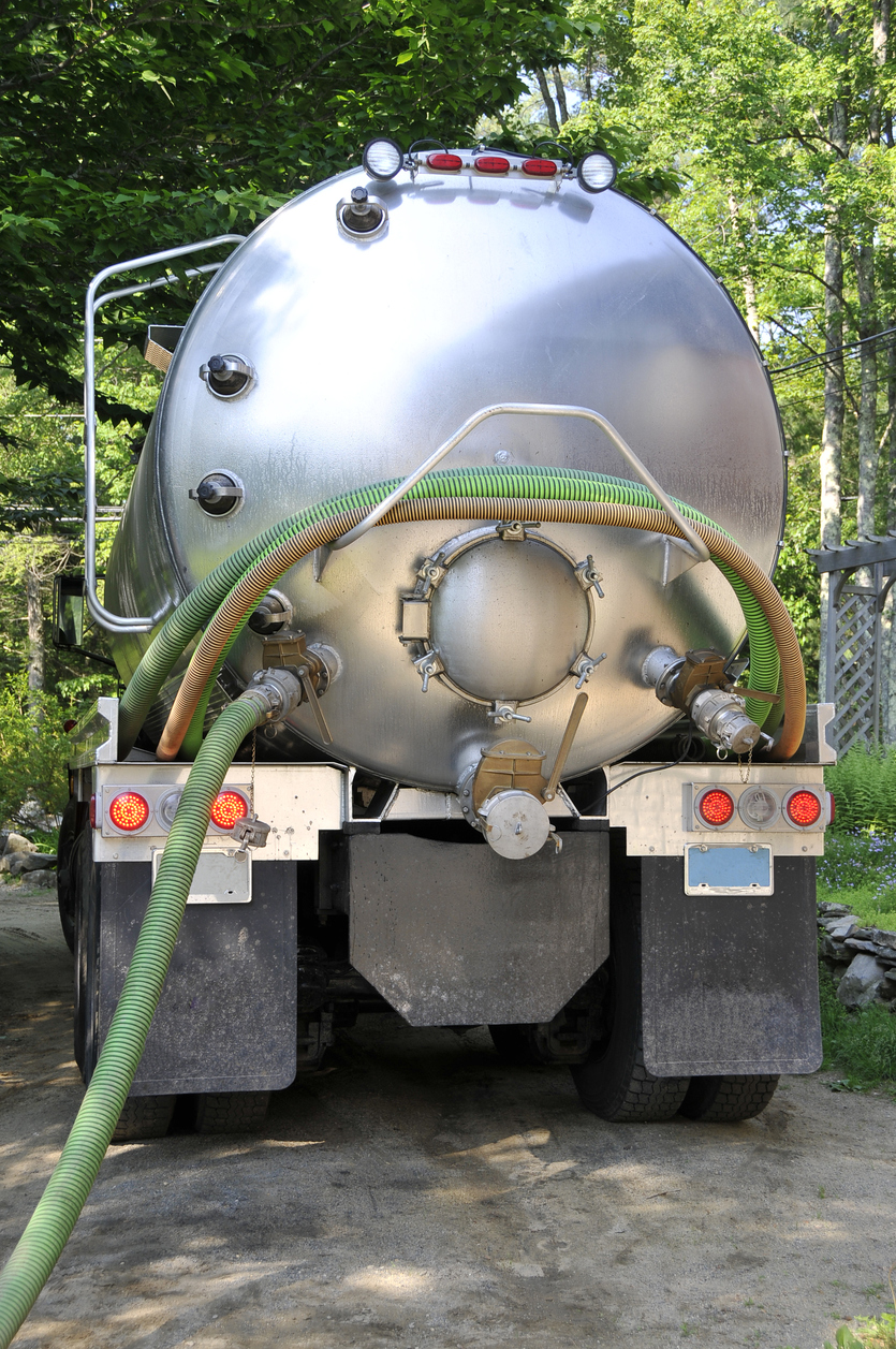 back of septic tank truck silver with ggreen house