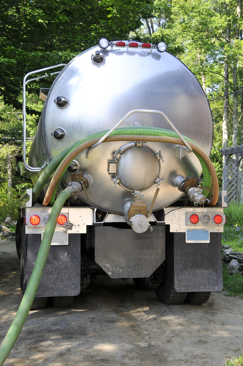 Affordable septic service back of septic tank truck silver with ggreen house